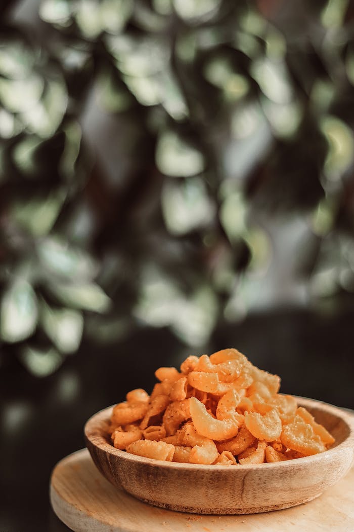 Indonesian snacks in a wooden bowl with a lush green background, perfect for culinary explorations.